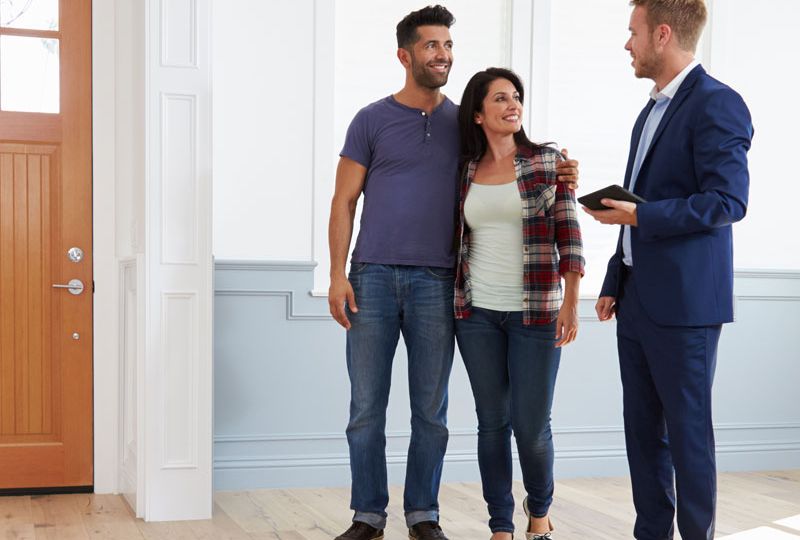 Photo of happy couple with sales man buying their new Help to Buy home