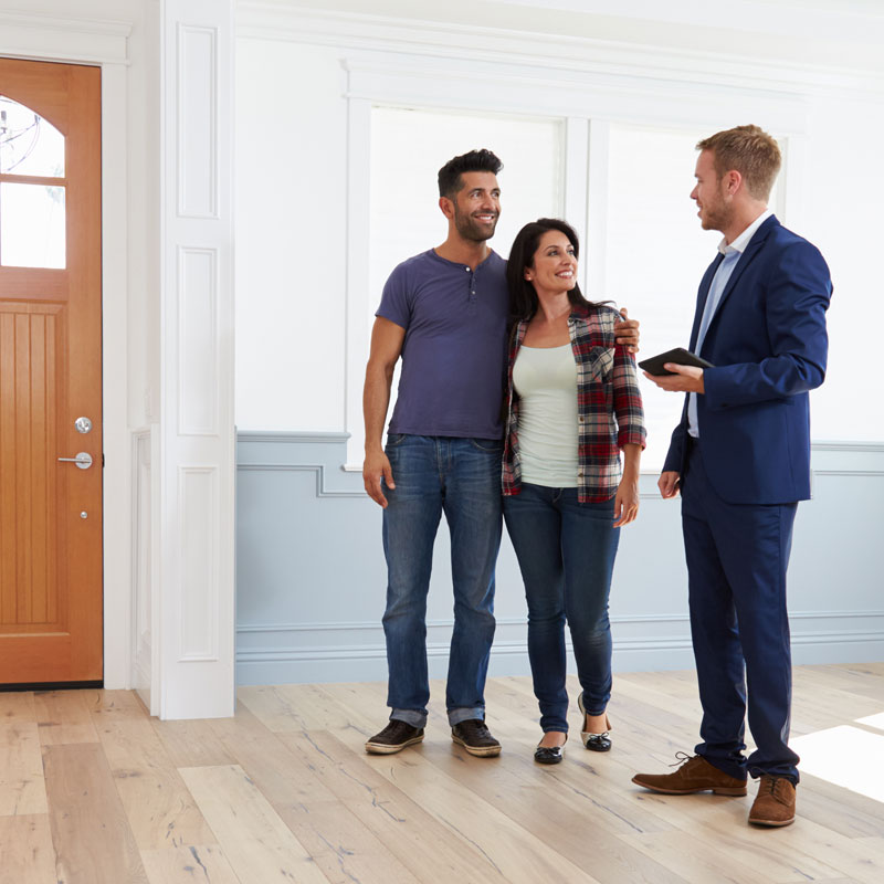 Photo of happy couple with sales man buying their new Help to Buy home