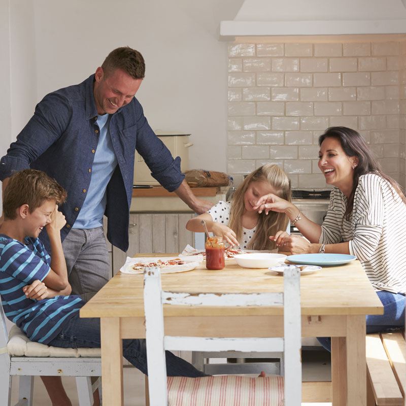 Picture of family laughing and happy in their house, they bought using Acclaimed Mortgage Consultancy